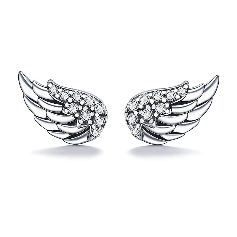 A pair of silver angel wing stud earrings, each adorned with small clear pavé gemstones, set against a clean white background.